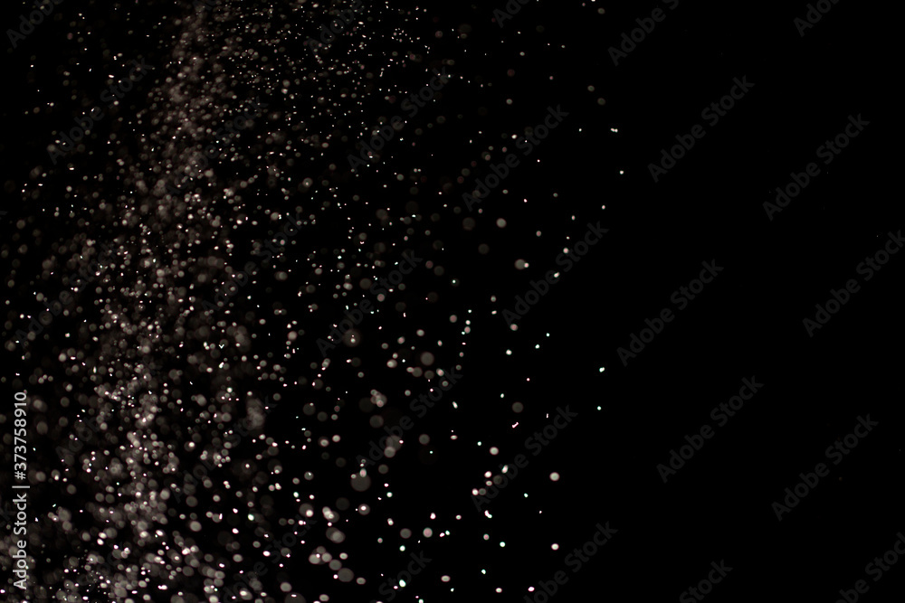 Obraz premium White dust on a black background, selective focus.