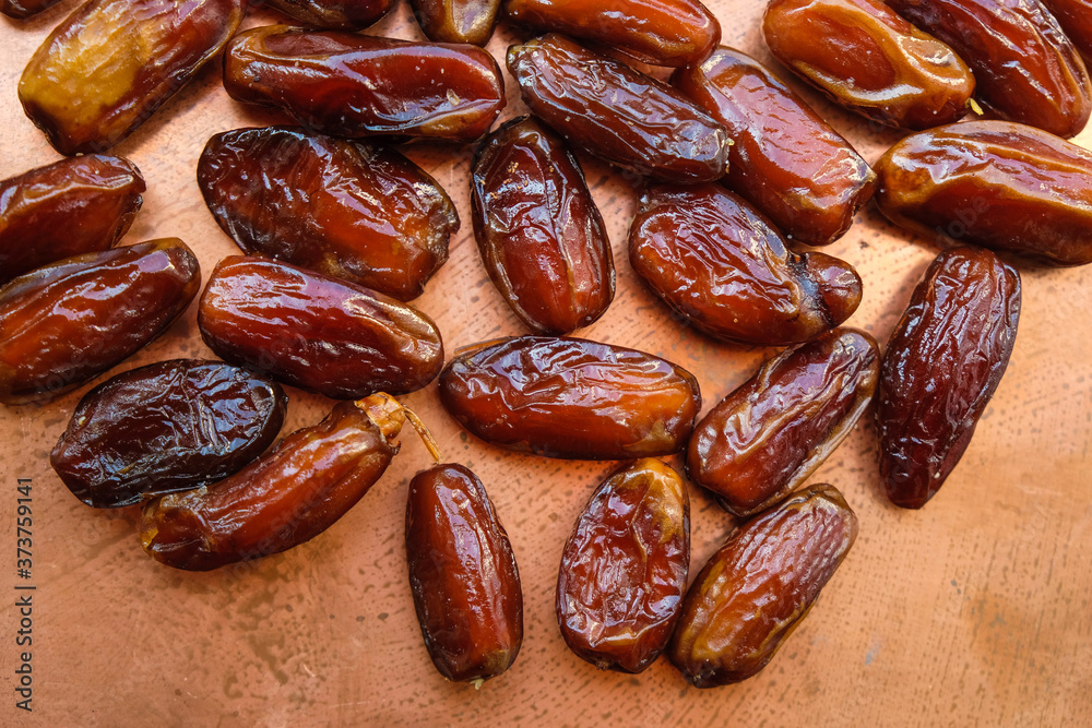 Dried dates on a copper surface. Monochrome image. Dried dates on a copper surface. Monochrome image.