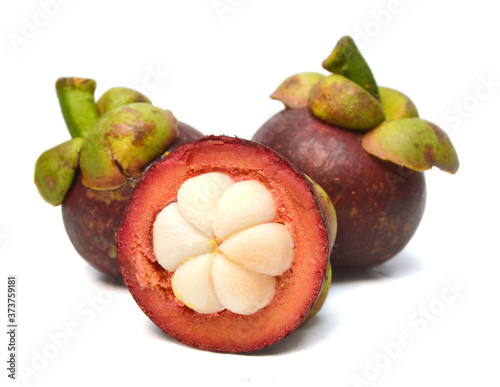Mangosteen fruit and cross section showing the thick purple skin and white flesh of the queen of fruits. 