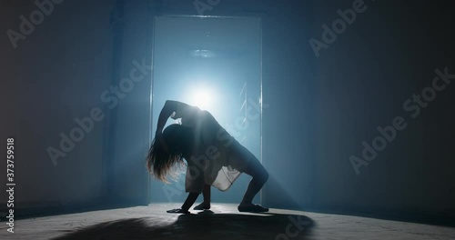 Scary female psychopath crawling in corridor of cursed house with unnatural moves. Exorcist girl awaken by demon - halloween concept 4k footage photo