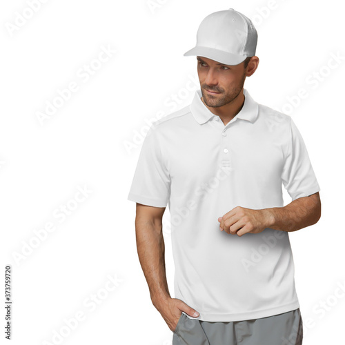 A handsome man stands on a white background, looking to his right with a smirk. Wearing a white baseball cap, white polo shirt, and gray shorts.