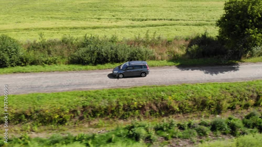 Aerial View Car Driving Road Agriculture Field in Summer Day. Road on Countryside Asphalt, Wheat Fields. Aerial View Road Trip Travel Journey Vacation Nature Countryside Rural Landscape.