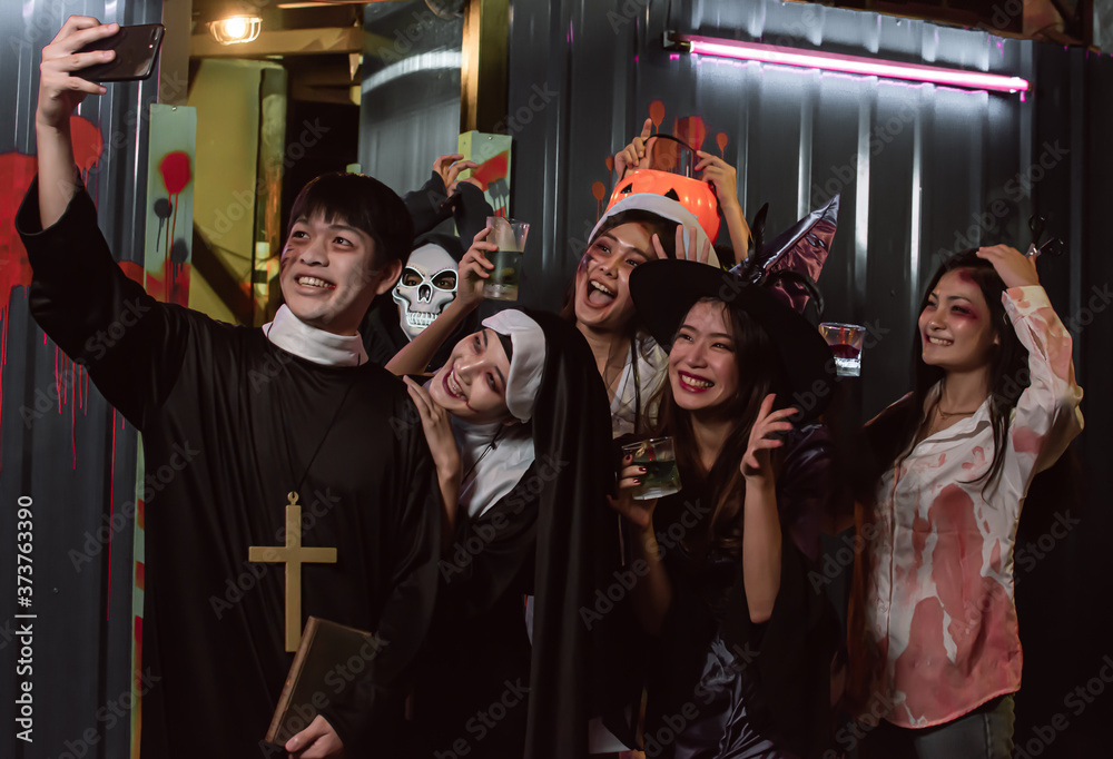 Portrait of young people dressing halloween costume and taking selfie in party