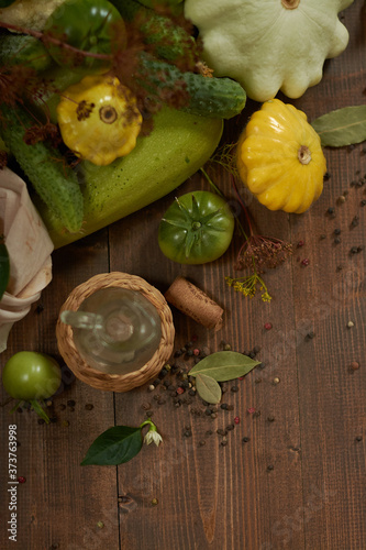  Fresh vegetables, peppercorns and a small glass jar on a wooden background flat lay.