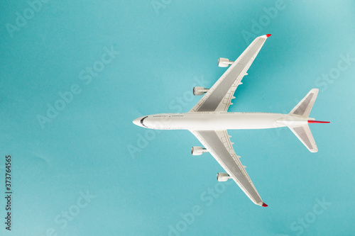 white airplane model over the turquoise background. travel concept
