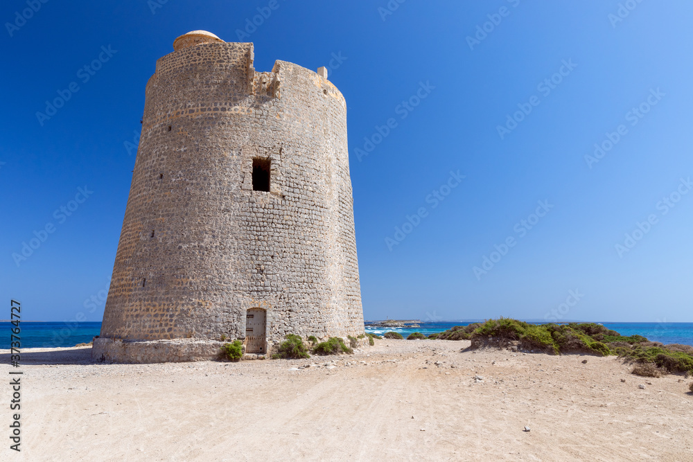 Beautiful view of the old observation tower Torre De Ses Portes on the coast of the Ibiza island.