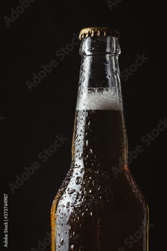 Macro shot of the bottle of  cold beer. Upper part of the wet glass bottle