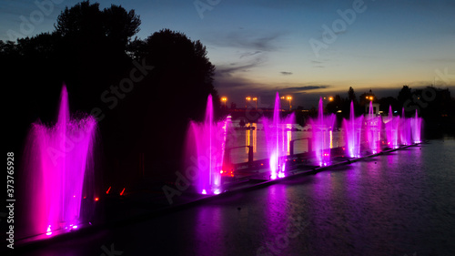 Colored fountain on the river at night.
