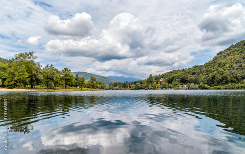 Landscape of Lake Ghirla with reflections of the clouds and trees in a summer day, Valganna, province of Varese, Italy photo