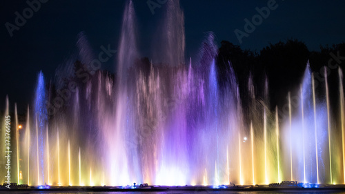 Colored fountain on the river at night.