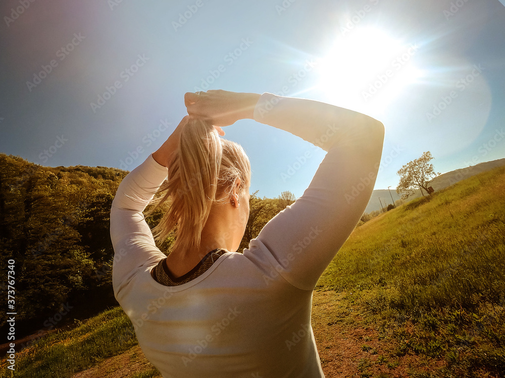 Φωτογραφία Back view photo of young blonde girl wearing sportswear tying a ponytail