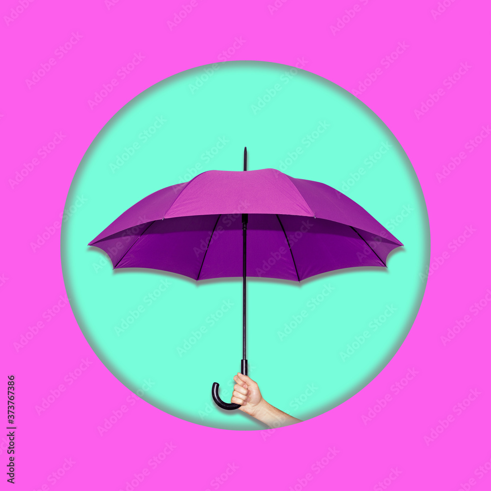 Contemporary collage. A man hand holds a purple umbrella on a turquoise background in a pink frame in the form of a circle.
