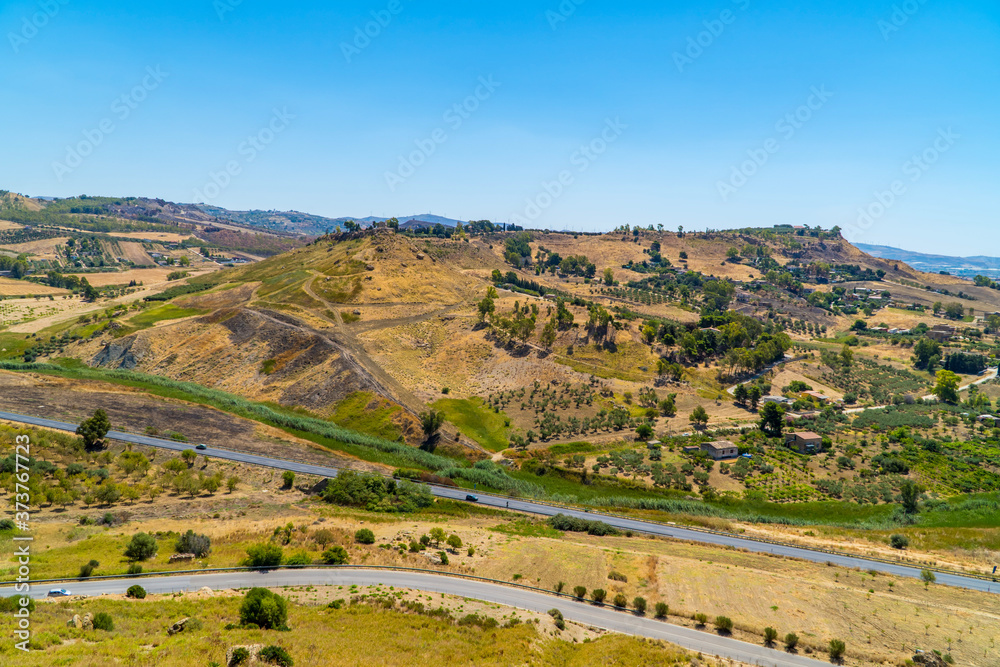Landscapes with roads, fields, and the sea in the background near Agrigento on the south coast of Sicily, Italy Landscapes with roads, fields, and the sea in the background near Agrigento on the south coast of Sicily, Italy