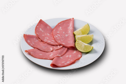slices of mortadella served with lemon .. top view
