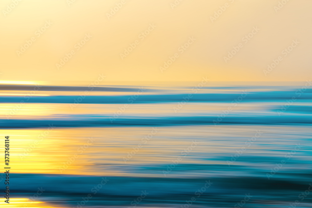 Abstract seascape with blur panning motion. Sunset over the sea, light blue and yellow colors