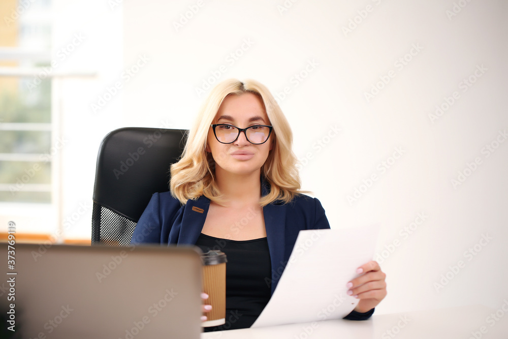 smiling blonde businesswoman with glasses using laptop in the office smiling blonde businesswoman with glasses using laptop in the office