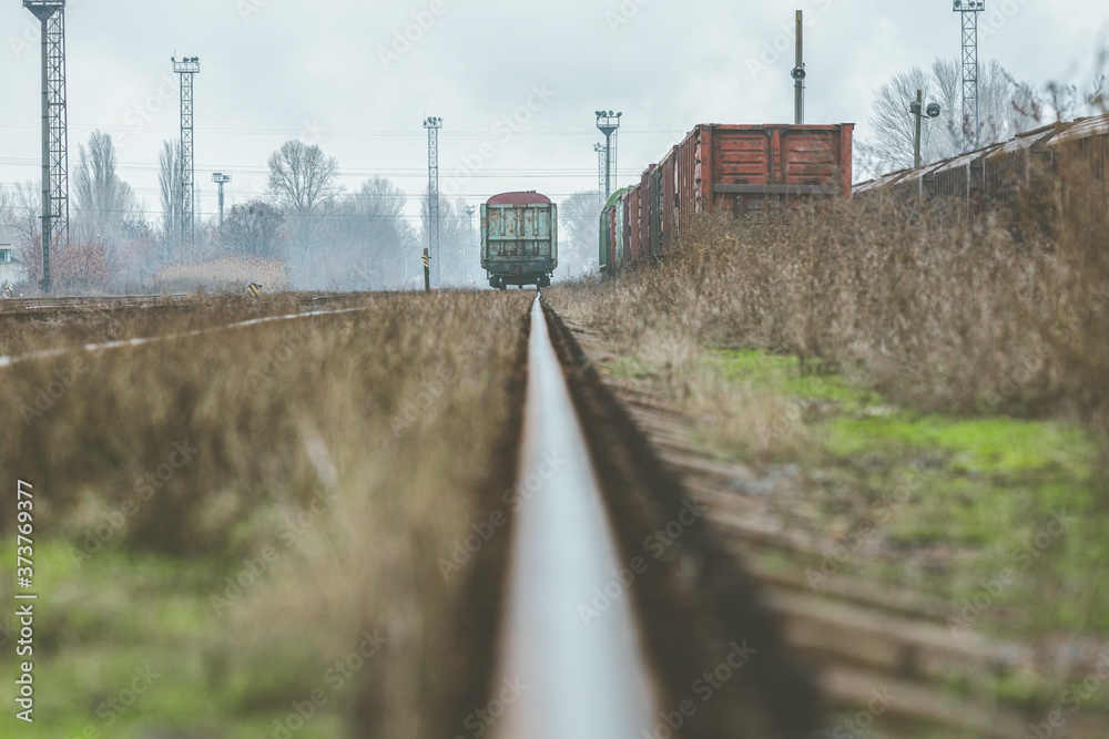 Detail of rail tracks in a suburban Railway Yard. Cloudy autumn day. Railway in fog on station, outdoor landscape.