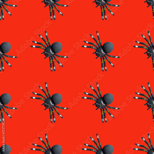 Seamless pattern with black spiders on a red background. Halloween theme. Simple drawing for any surface.