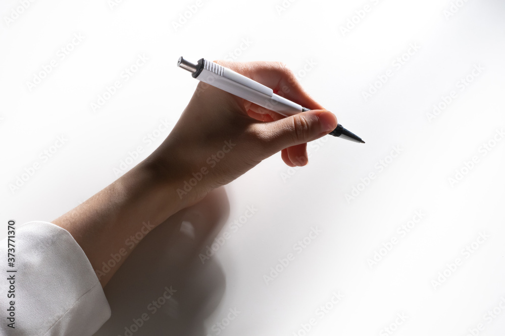 A woman hand with a ballpoint pen. Handwritten text. The person is holding a pen in his hand.