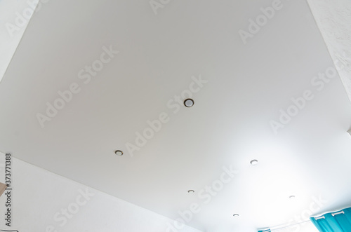 Fragment of the room's interior - white matte stretch ceiling with a series of spotlights