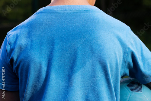 sweat on a child's blue t-shirt in close-up
