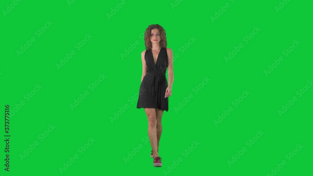 Young beauty woman fashion model walking on catwalk in slow motion on green screen chroma key background. Young beauty woman fashion model walking on catwalk in slow motion on green screen chroma key background.