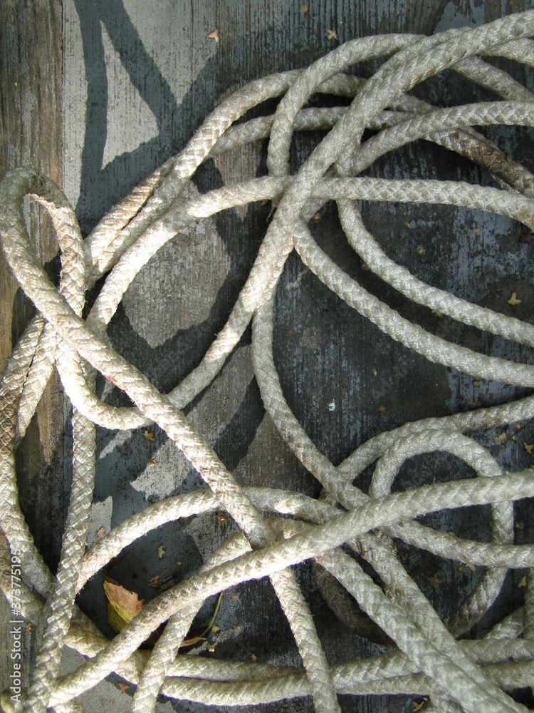 a skein of white rope on a gray wooden board a skein of white rope on a gray wooden board