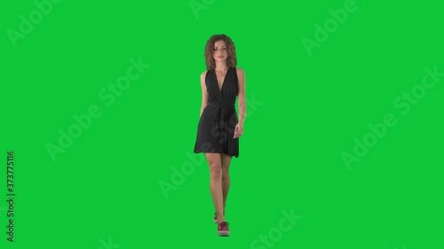 Young beauty woman fashion model walking on catwalk in slow motion on green screen chroma key background. 
