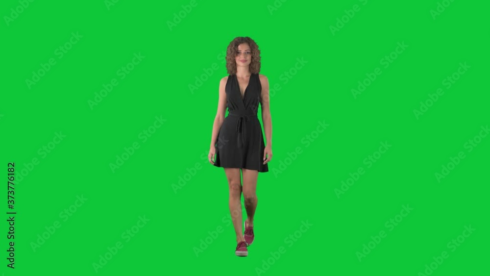 Happy casual style woman in mini dress walking and smiling at camera on green screen chroma key background. Happy casual style woman in mini dress walking and smiling at camera on green screen chroma key background.