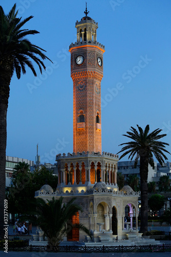 The iconic Clock tower is seen illuminated at Konak district during a beautiful sunset in the coastal city of Izmir, Turkey.