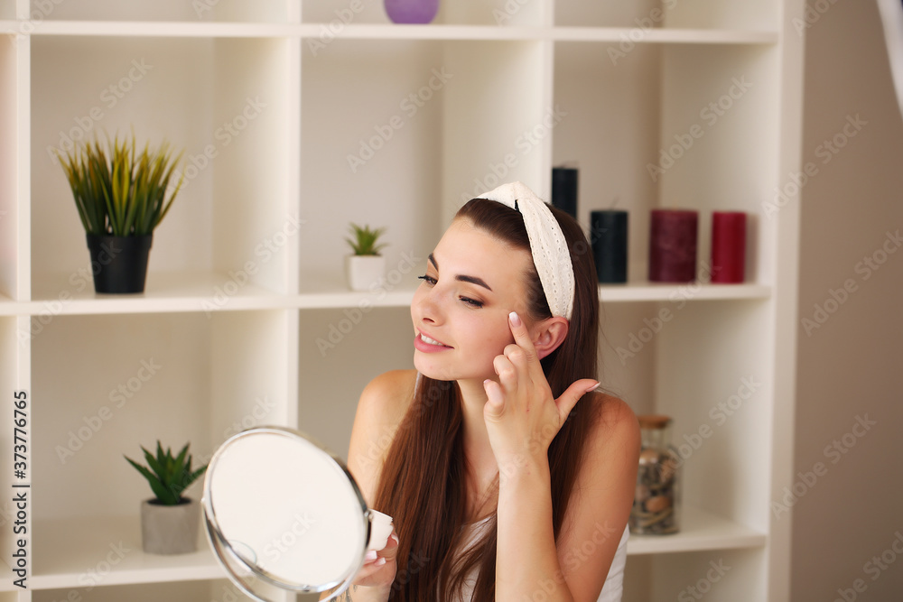 face of young beautiful healthy woman looking in the mirror