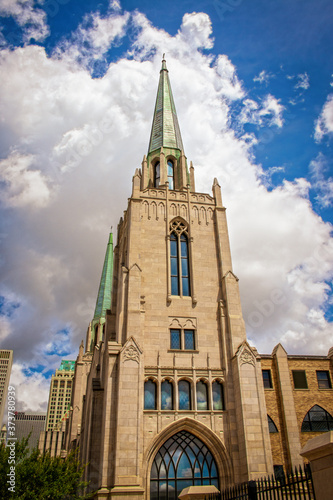 Cityscape of Tulsa Oklahoma USA with gothic chruch with copper spires in foreground