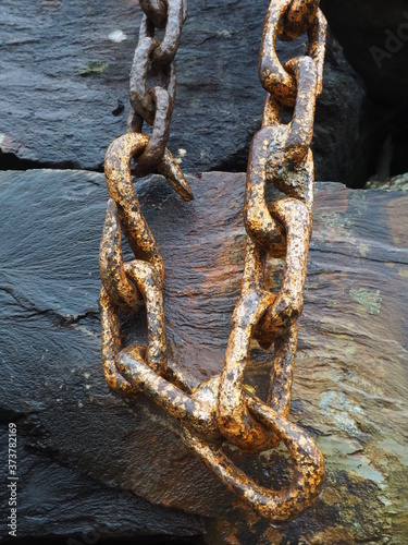 Hook on a chain hanging against a wooden background