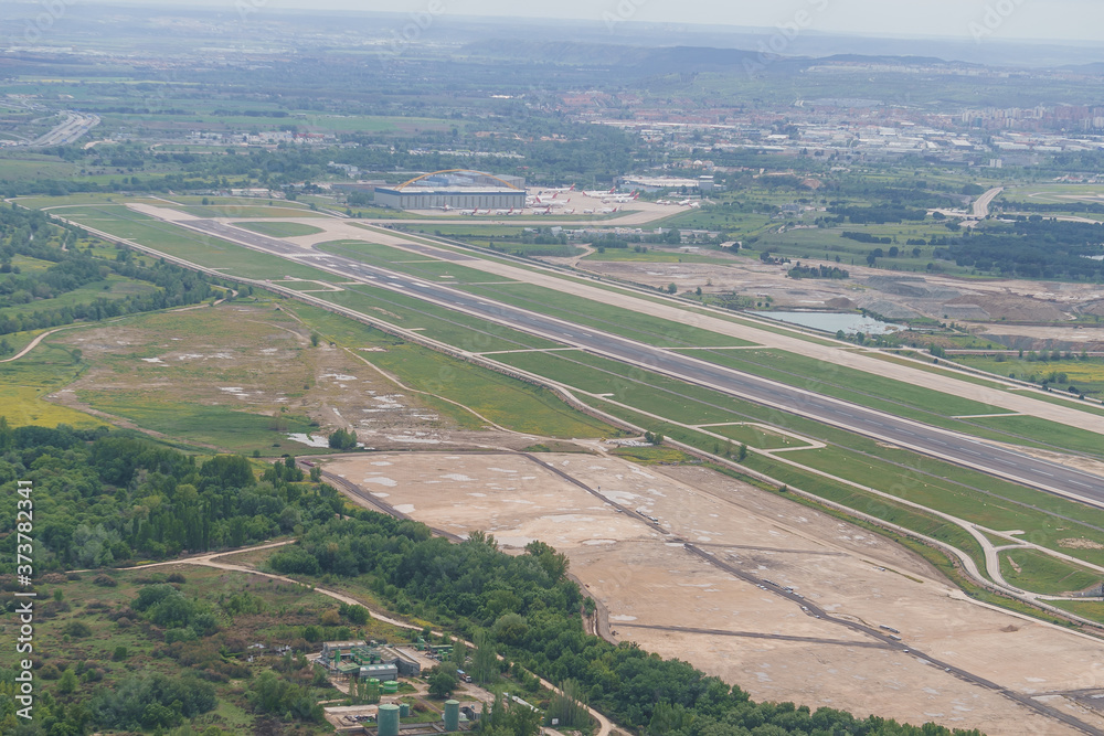 Aerial view of one of the runways at Adolfo Suarez airport and surroundings on a cloudy day.