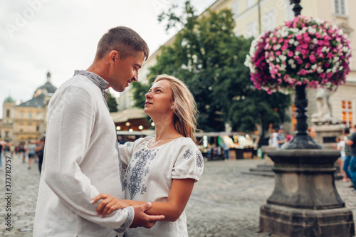 Loving couple walking in old Lviv city wearing traditional national ukrainian shirts. Newlyweds spend time together © maryviolet