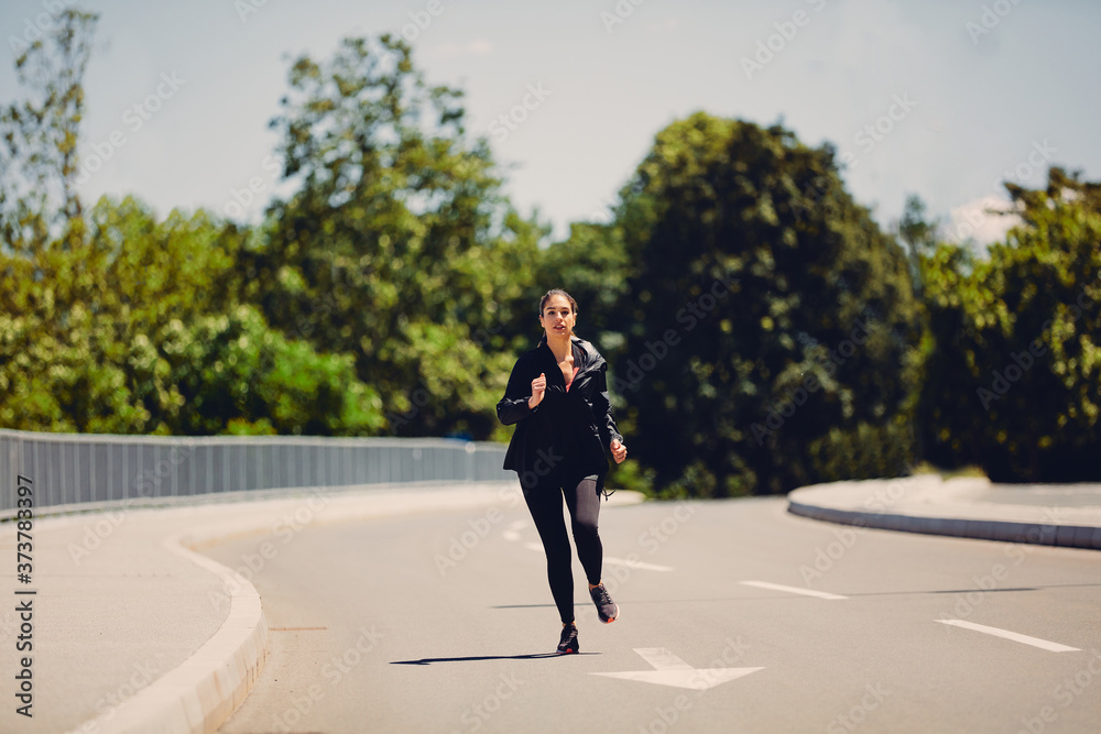 Full length of attractive runner in shape running on asphalt.