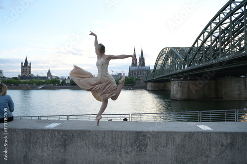 A beautiful ballet dancer ballerina outdoors ,Ballerina dancing on the bridge in Cologne City .