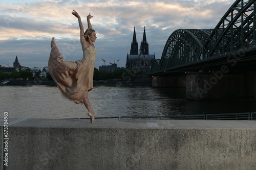 A beautiful ballet dancer ballerina outdoors ,Ballerina dancing on the bridge  in Cologne City . photo