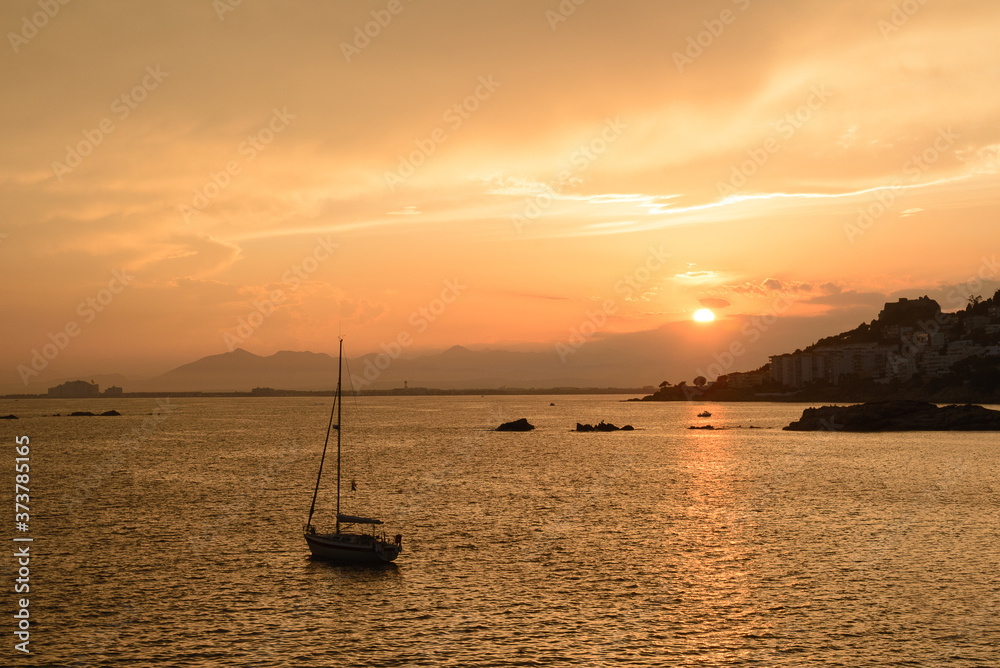 Velero navegando en la bahía de Rosas, en Alt Empordà , Cataluña al Atardecer