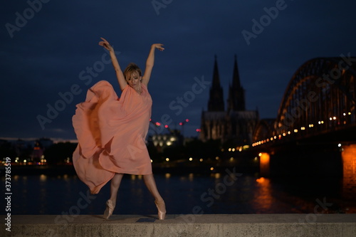 A beautiful ballet dancer ballerina outdoors ,Ballerina dancing on the bridge in Cologne City .