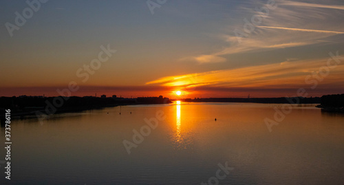 Orange sunset over the river on a summer evening