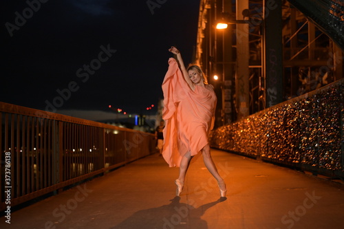 A beautiful ballet dancer ballerina outdoors ,Ballerina dancing on the bridge in Cologne City .
