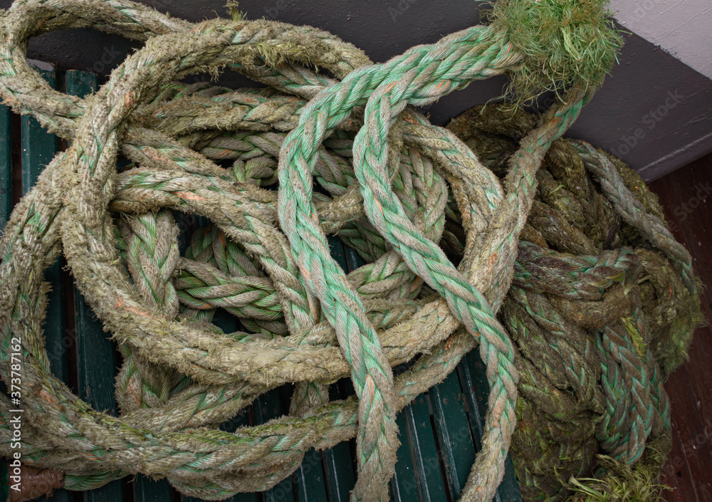 Closeup view of an old green frayed boat rope. Nautical background. 