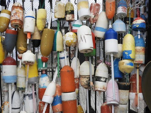Colorful old buoys hanged on a wall at the port