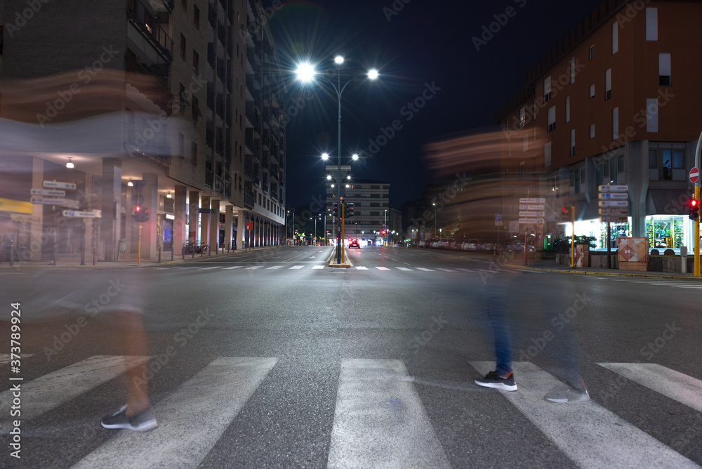 Fototapeta premium Timelapse view of traffic at an urban night intersection. Urban movement in the Italian city in the evening.