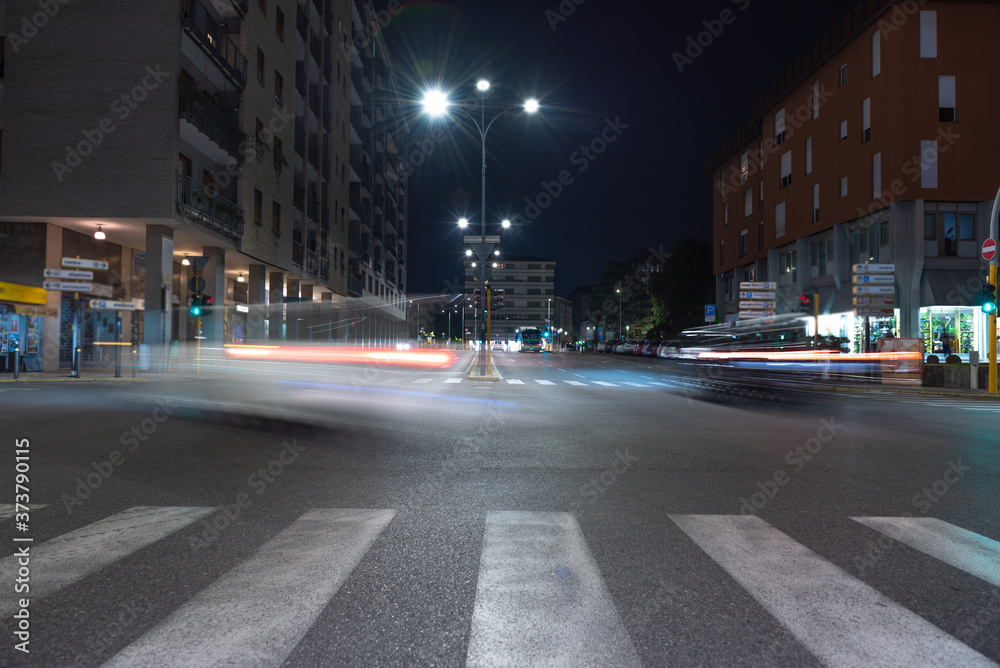 Timelapse view of traffic at an urban night intersection. Urban movement in the Italian city in the evening. Timelapse view of traffic at an urban night intersection. Urban movement in the Italian city in the evening.