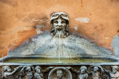 Italy, Rome. Via Condotti, small wall fountain. photo