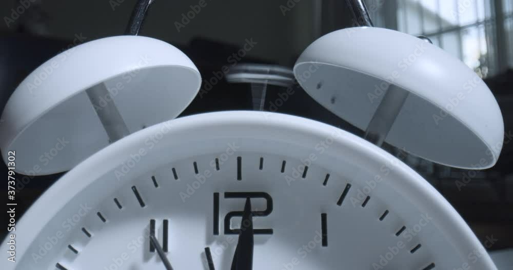 Macro Alarm Clock Rings. Extreme macro wide angle close up as the hammer rings the bells on a small alarm clock with raised 3D numbers.