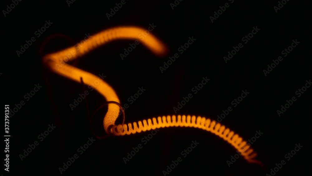 Macro View of an Incandescent filament glows and turns off slowly controlled by a dimmer.
Macro View of an Incandescent filament glows and turns off slowly controlled by a dimmer.