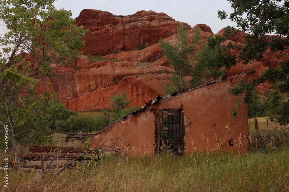 Abandoned rustic building with red rock sandstone in the background Abandoned rustic building with red rock sandstone in the background